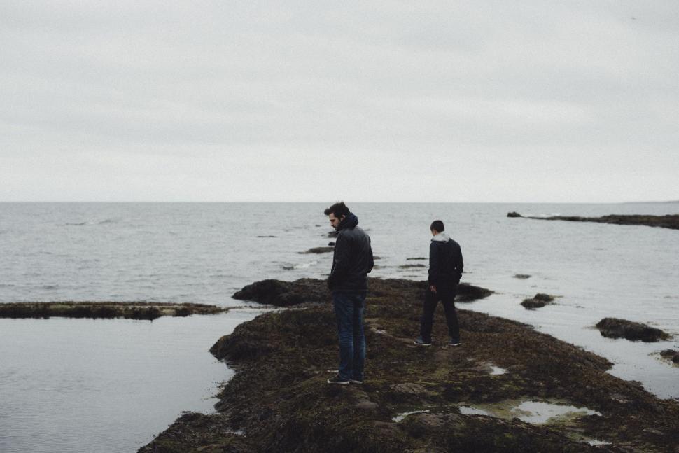 Free Image of Couple Standing on Top of Rocky Beach 