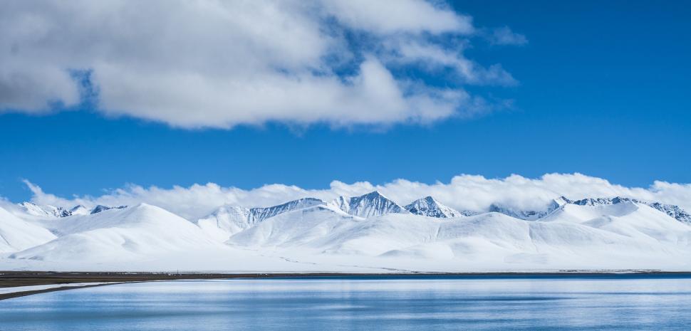 Free Image of Majestic Snow-Covered Mountains Surrounding a Vast Body of Water 