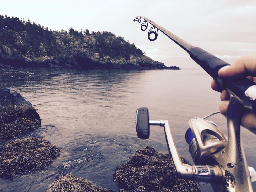 Free Image of Person Holding Fishing Rod by Water 