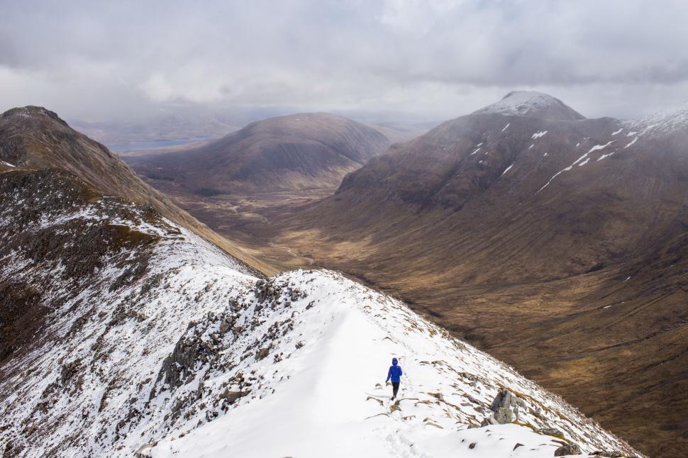 Free Image of Person Walking Up Snow Covered Mountain 