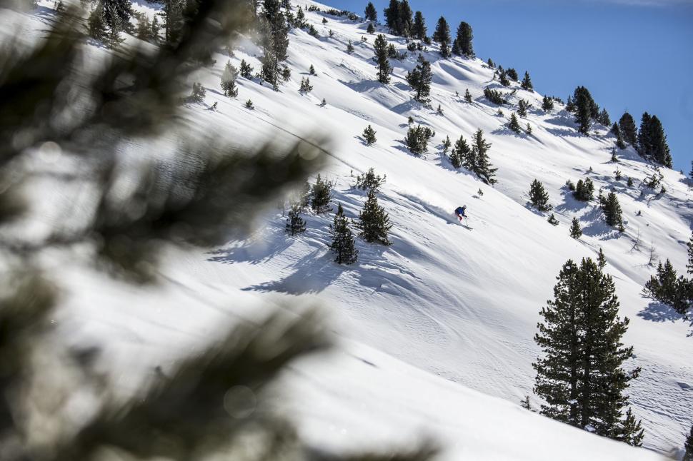 Free Image of Person Riding Snowboard Down Snow-Covered Slope 