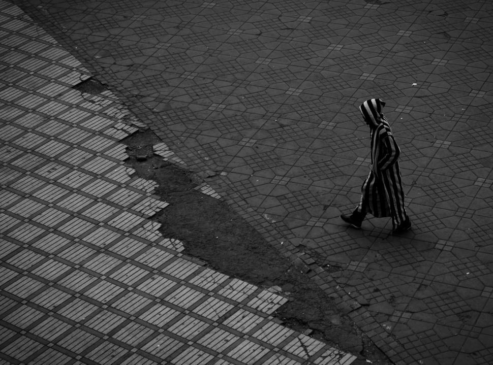 Free Image of Person Walking Down Street Near Puddle 