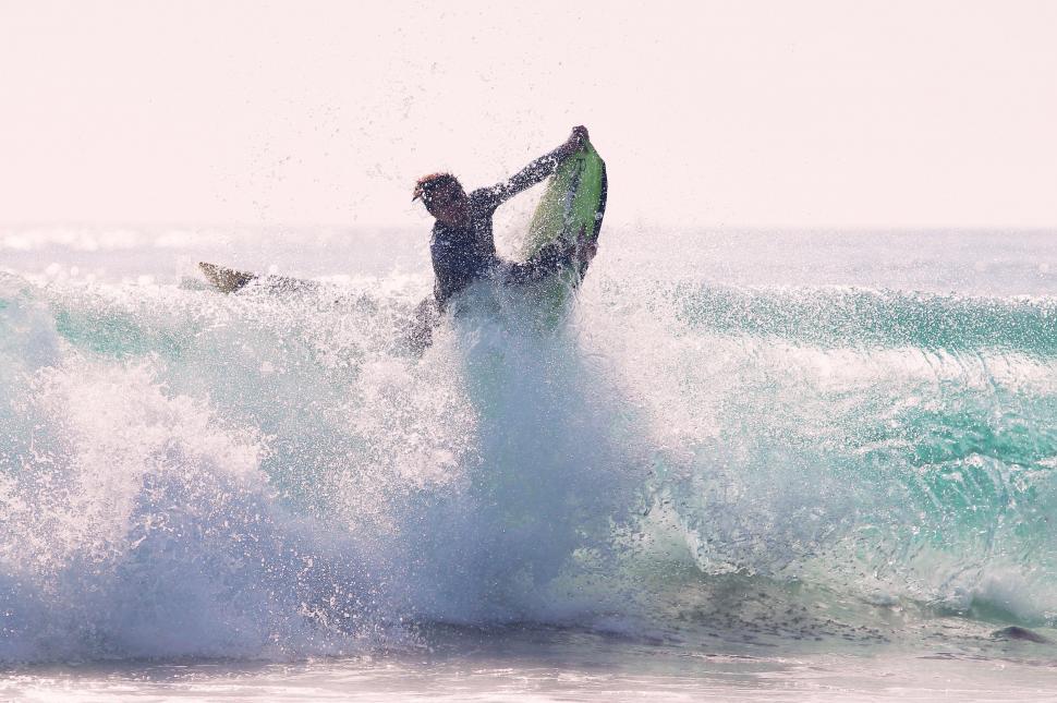 Free Image of Man Riding Wave on Surfboard 