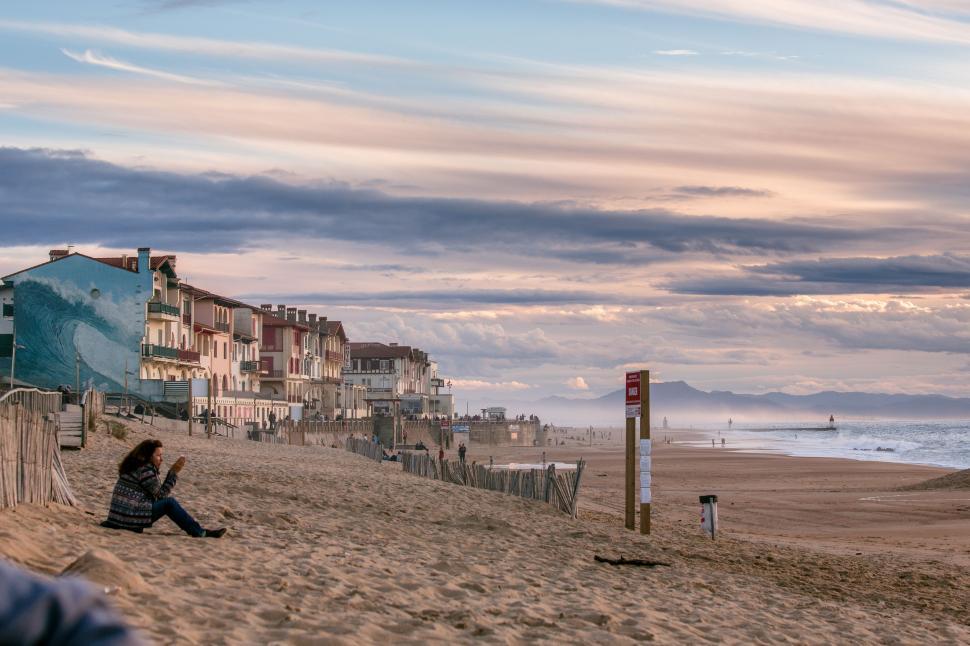 Free Image of Person Sitting on Beach Next to Ocean 