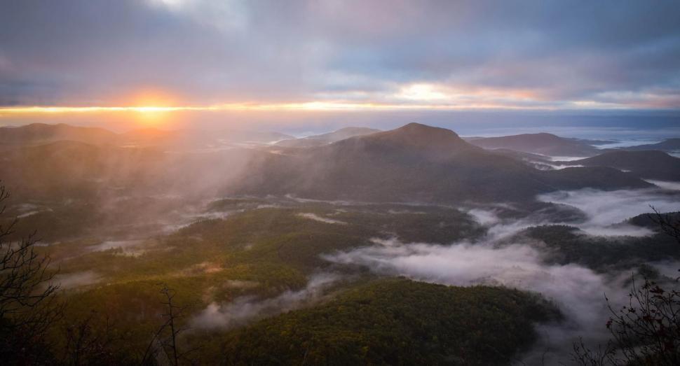 Free Image of Sun Shines Through Clouds Over Mountains 