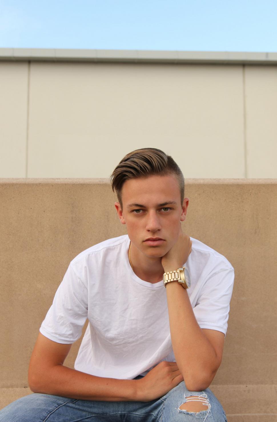 Free Image of Man Sitting on Bench With Hand on Chin 