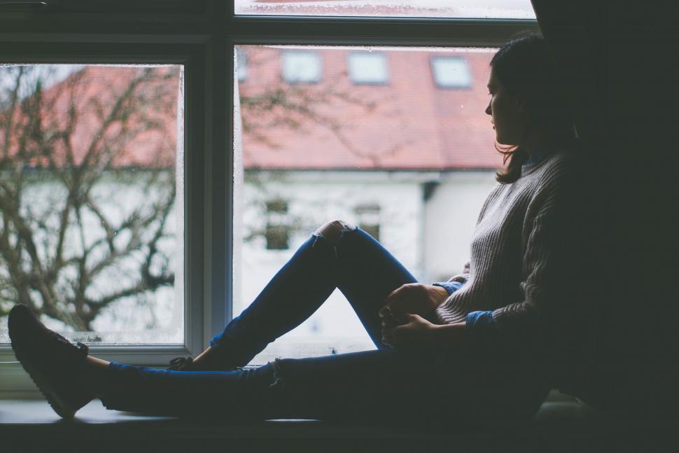 Free Image of Woman Sitting on Window Sill 