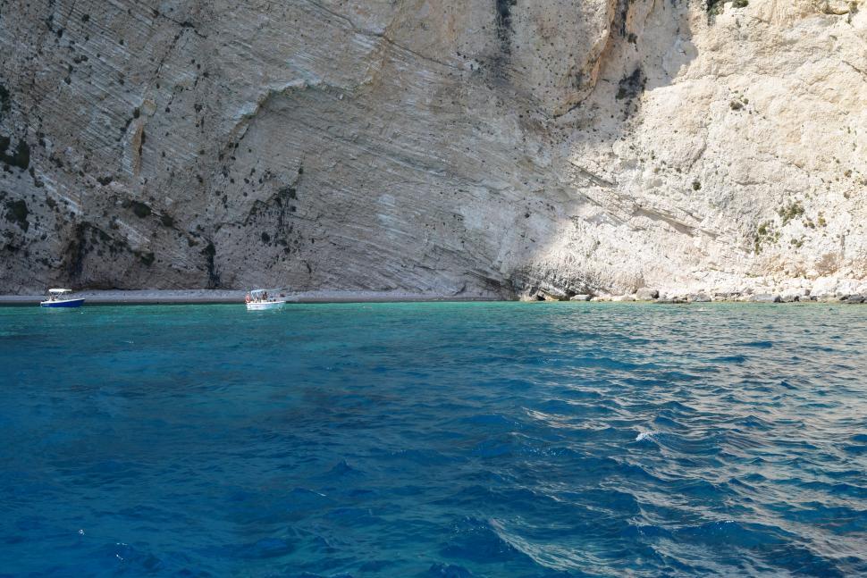 Free Image of Rocky shoreline and boats of the Mediterranean Sea in Greece  