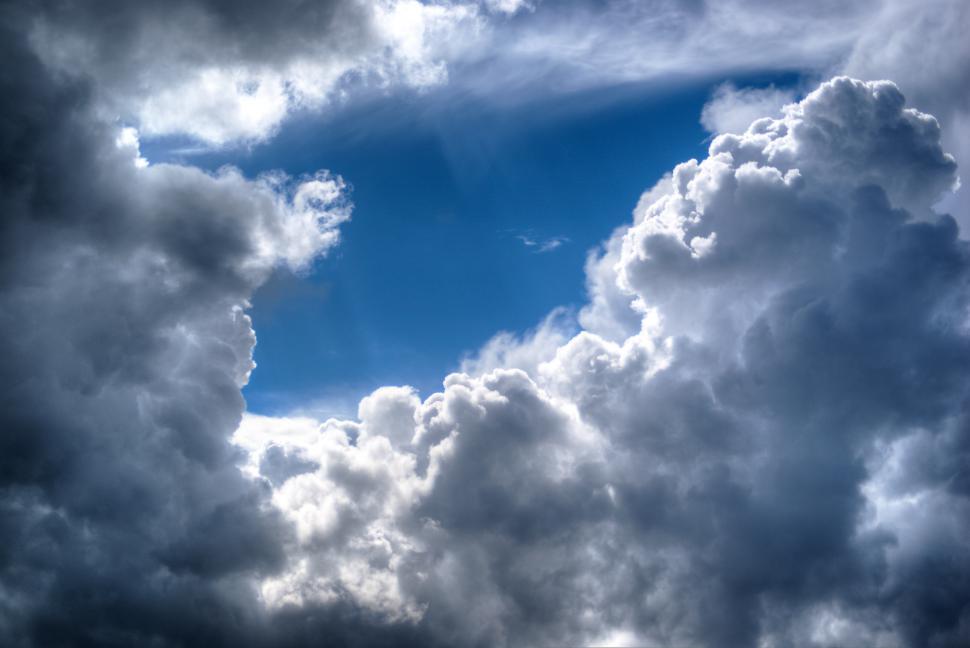 Free Image of Plane Flying Through Cloudy Blue Sky 
