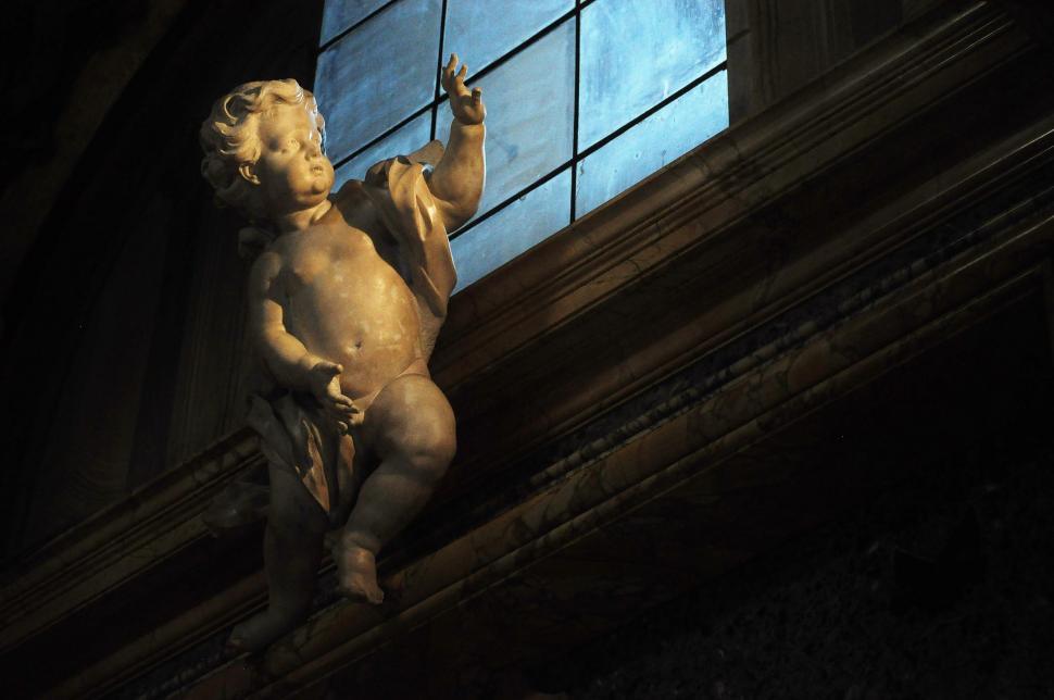 Free Image of Statue of a Child Holding a Cell Phone 