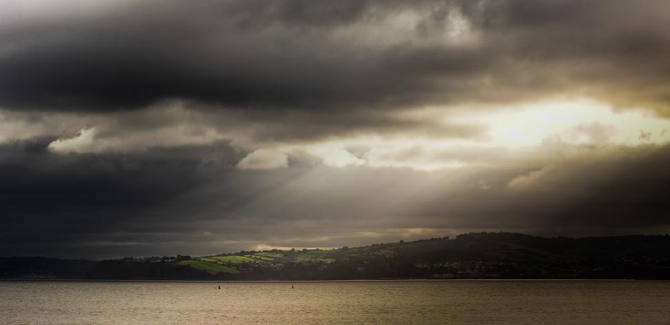 Free Image of Cloudy Sky Over Large Body of Water 