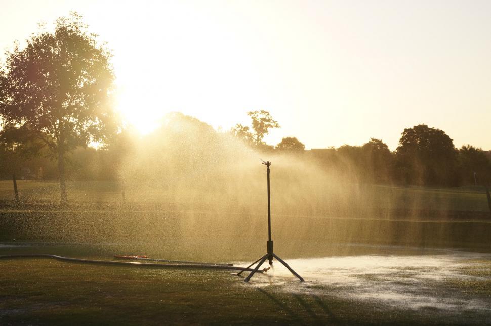 Free Image of Fire Hydrant Spewing Water Onto Field 