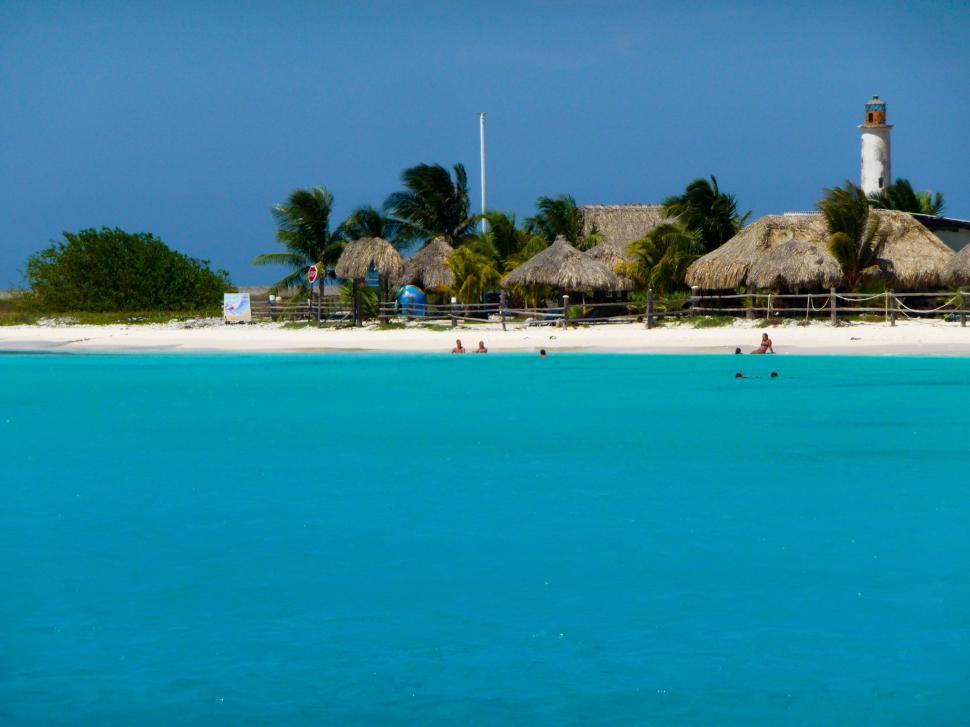 Free Image of A View of a Beach With a Lighthouse in the Background 