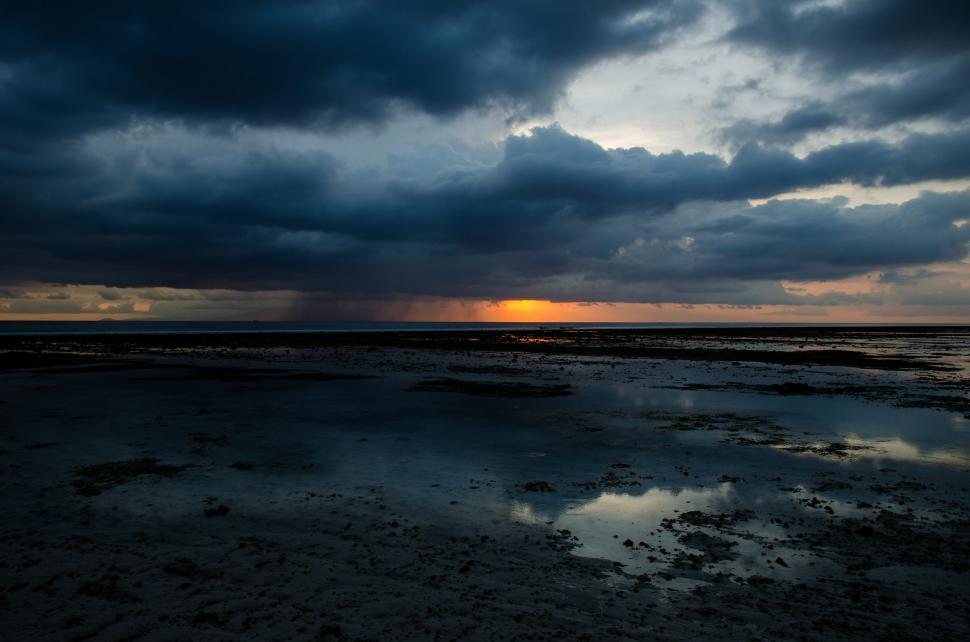 Free Image of Cloudy Sky Reflecting in Wet Sand 