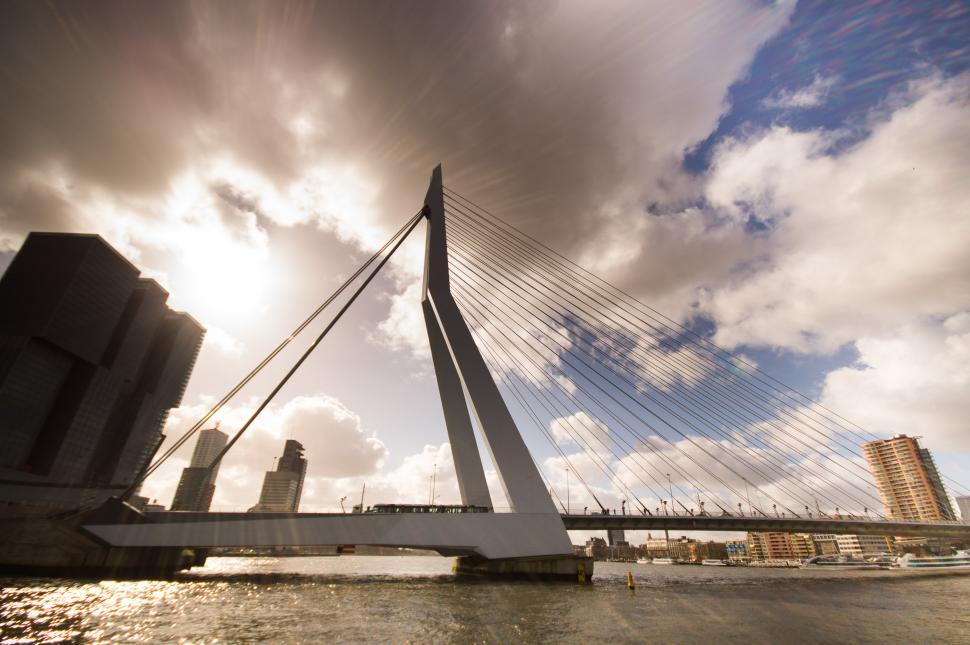 Free Image of Sun Shining Through Clouds Over Bridge 