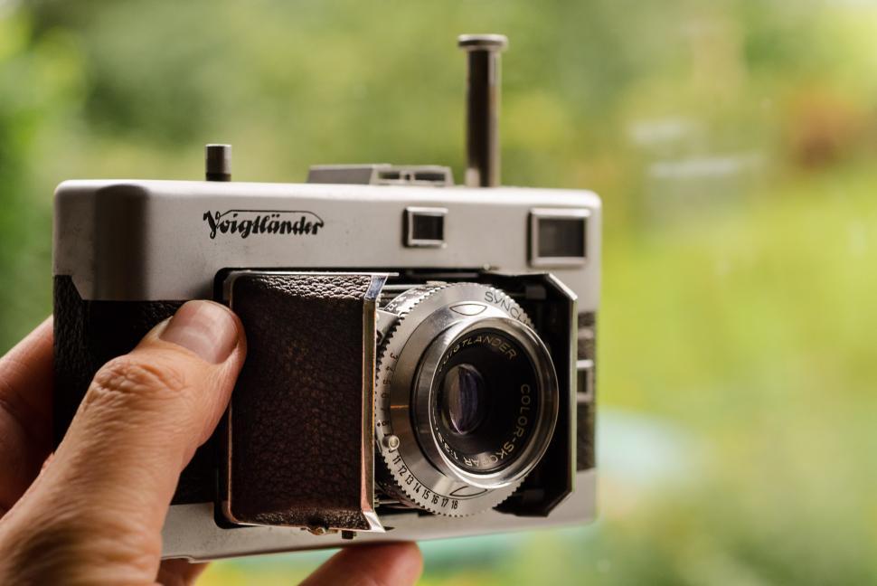 Free Image of Person Holding Camera in Front of Window 