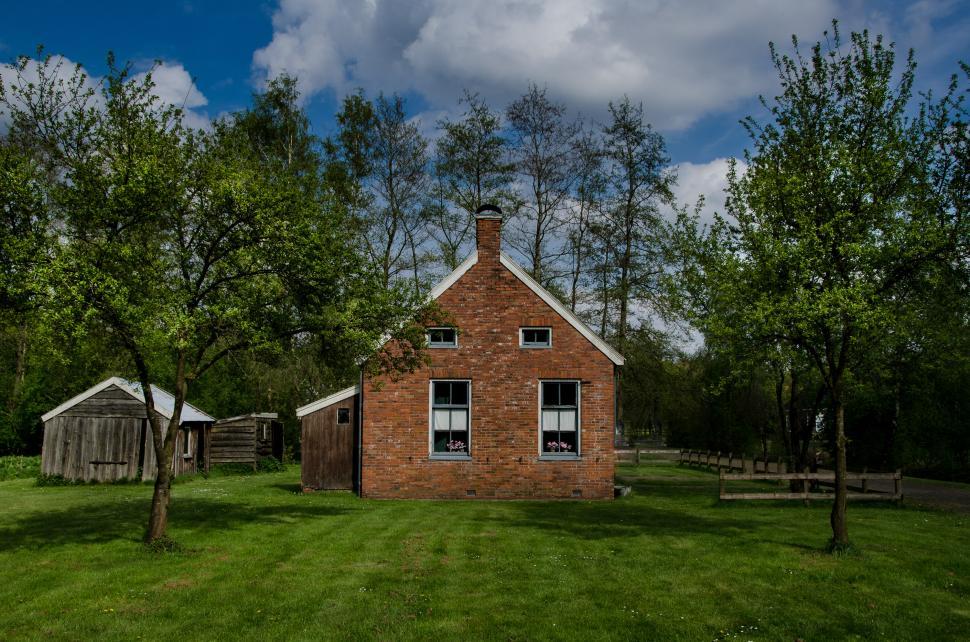 Free Image of Red Brick House on Lush Green Field 