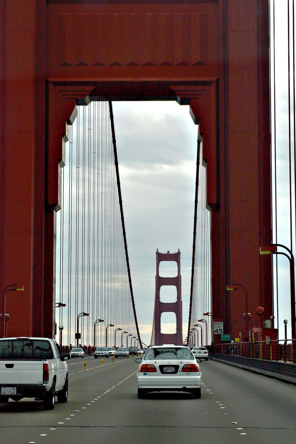 Free Image of Cars Driving Across a Bridge on a Cloudy Day 