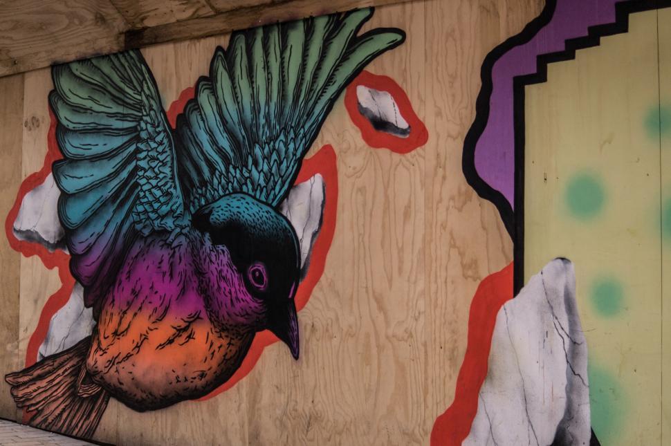 Free Image of Colorful Bird Painting on Wooden Wall 
