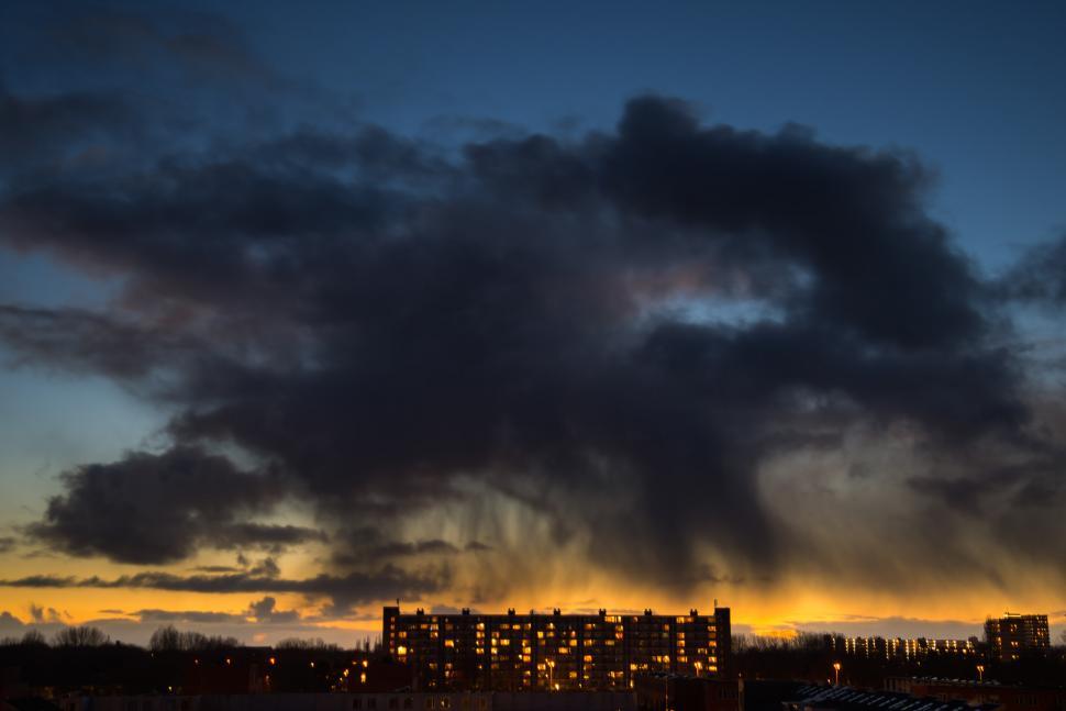 Free Image of Cloudy Sky With a Building in the Distance 