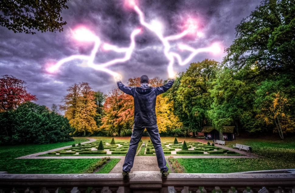 Free Image of Man Standing on Balcony With Hands Raised 
