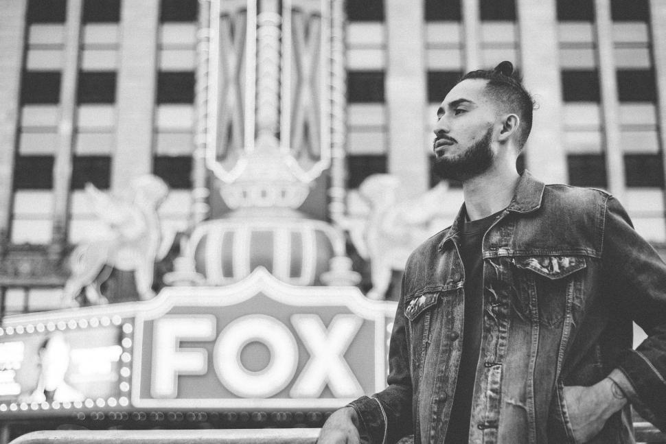 Free Image of Black and white photograph of a bearded  young man wearing a denim jacket 