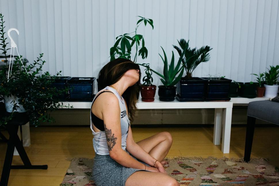 Free Image of Woman Sitting on Rug in Room 