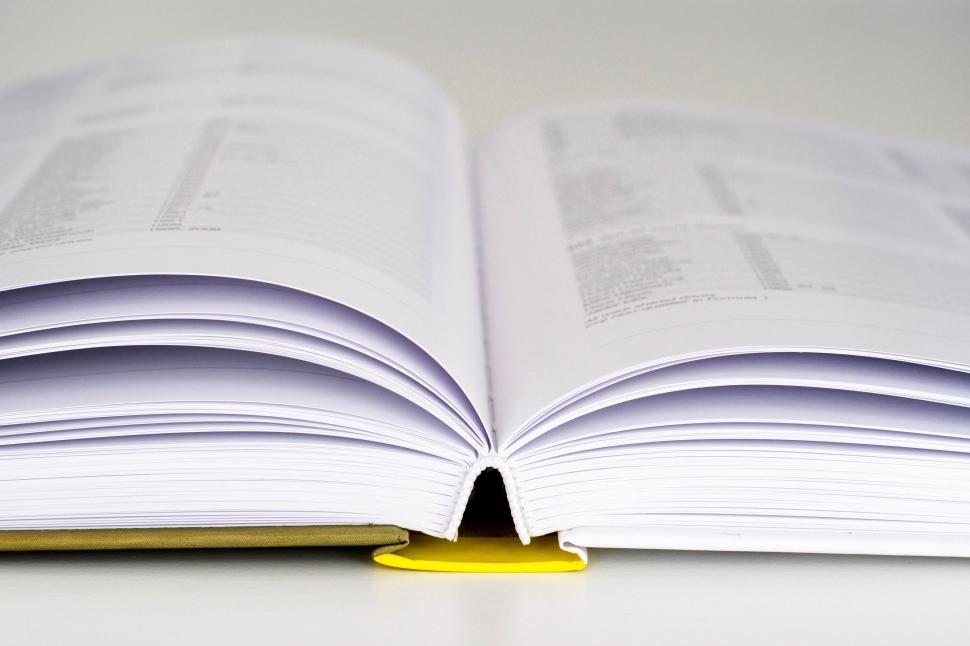 Free Image of Open Book on White Table 