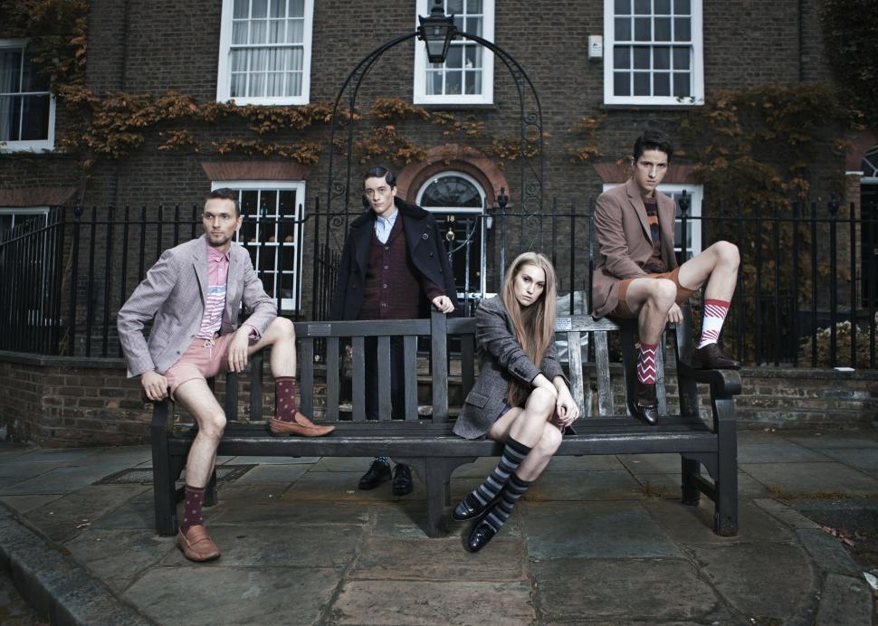Free Image of Group of People Sitting on Bench in Front of Building 