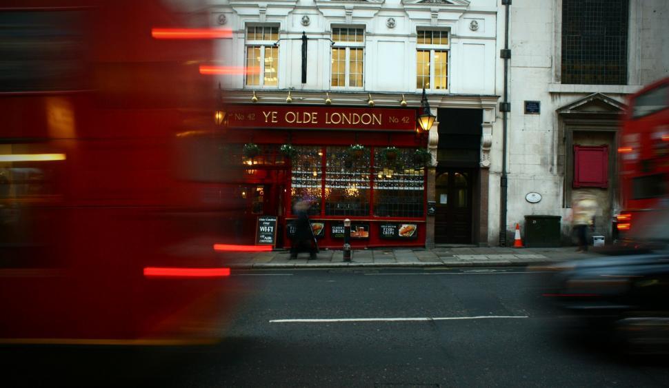Free Image of Red Double Decker Bus Passing Tall Building 