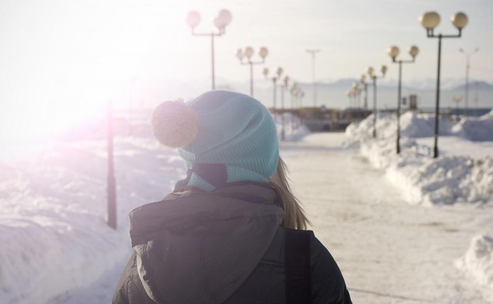 Free Image of Woman Walking Down a Snow Covered Sidewalk 