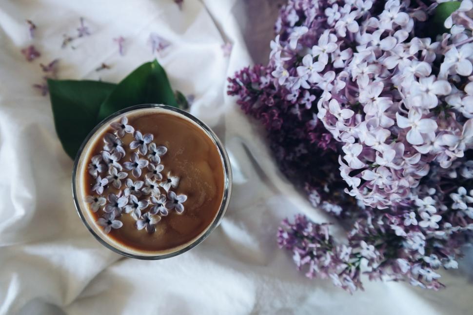 Free Image of Close Up of Coffee Cup With Flowers in Background 
