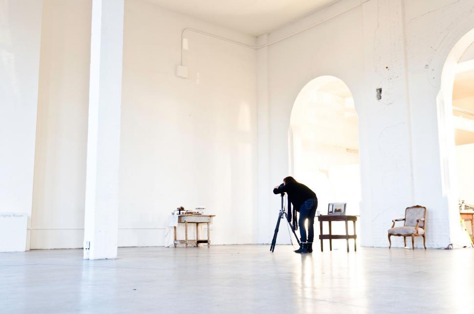 Free Image of Person Standing in Room With Chairs and Tables 