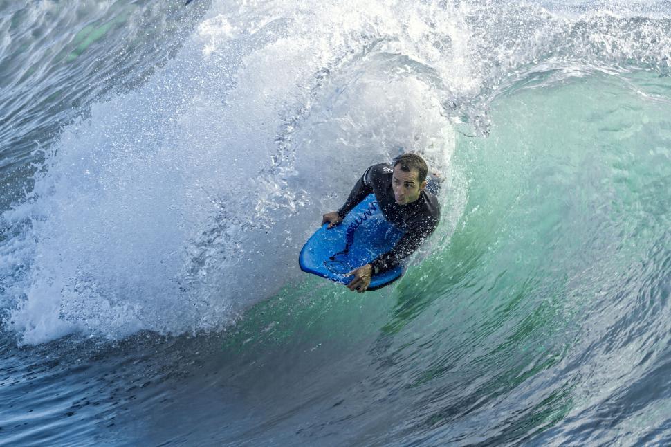 Free Image of Man Riding Wave on Surfboard 