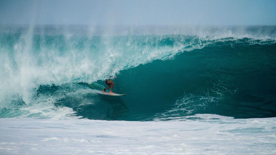 Free Image of Man Riding a Wave on Surfboard 