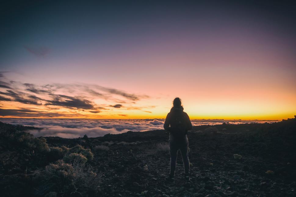 Free Image of Person Standing on Top of a Mountain at Sunset 