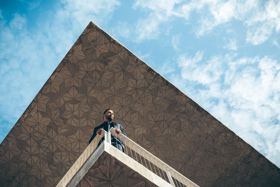 Free Image of Man Standing on Ladder in Front of Building 