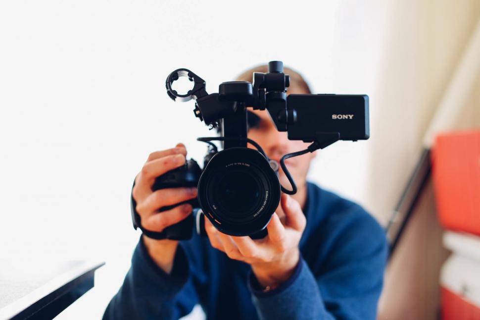Free Image of Man Holding Camera in Front of Mirror 