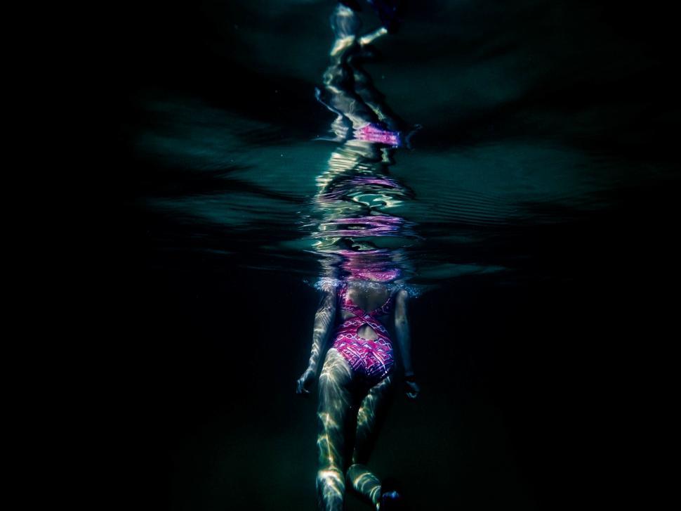 Free Image of Woman in Pink Swimsuit Floating in Water 