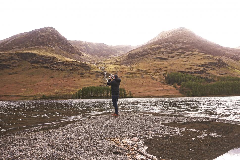 Free Image of Person Standing in Field With Mountains in Background 