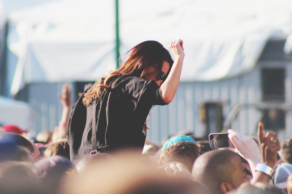 Free Image of Man With Long Hair Standing in Front of a Crowd 