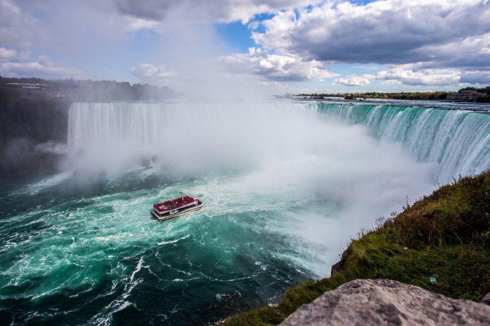 Free Image of Boat Sailing Near Waterfall 