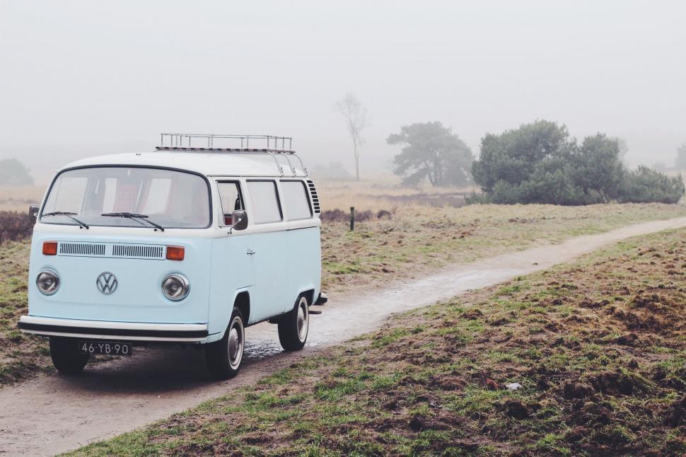 Free Image of VW Bus Driving Down a Dirt Road 