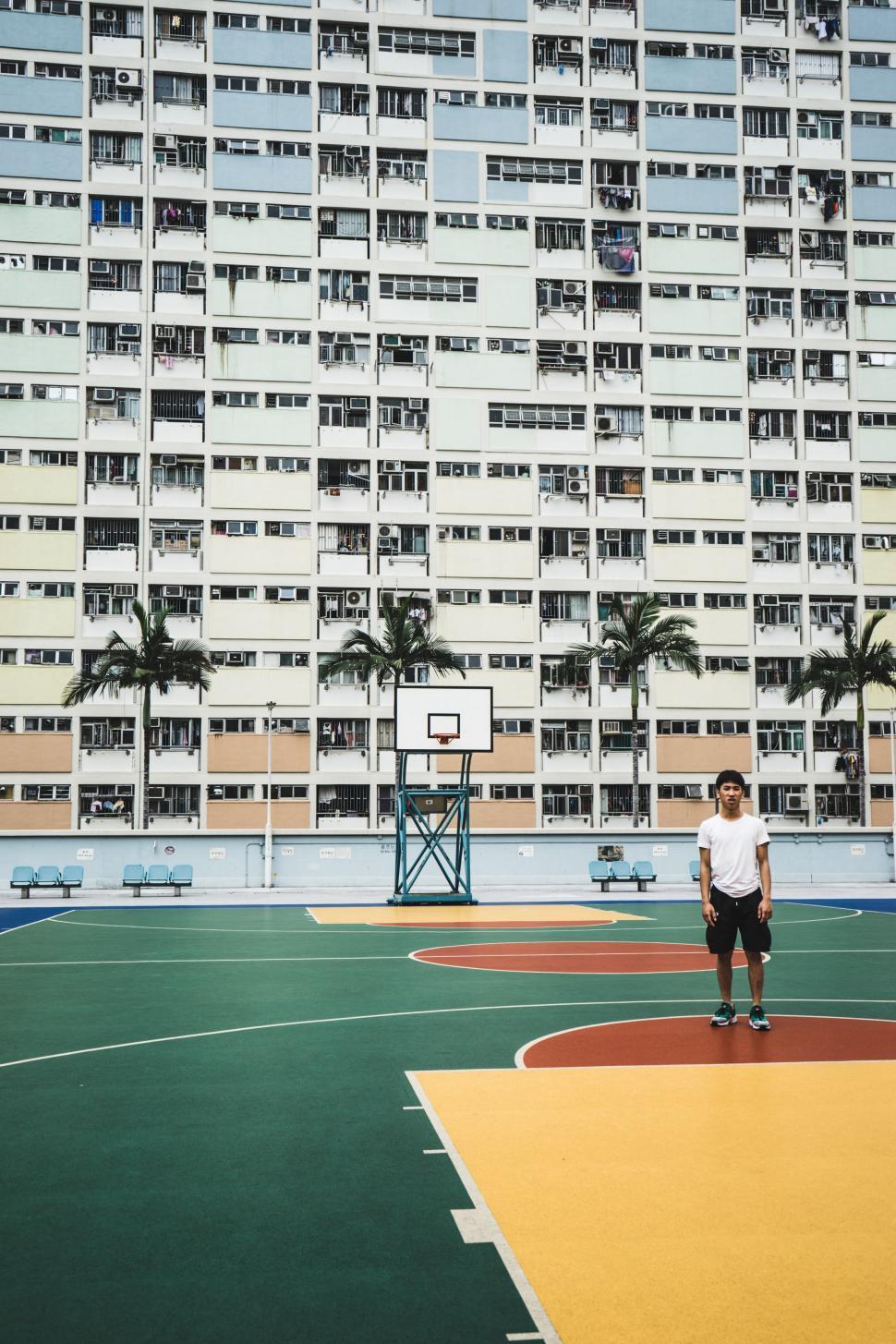 Free Image of Man Standing on Top of Basketball Court 
