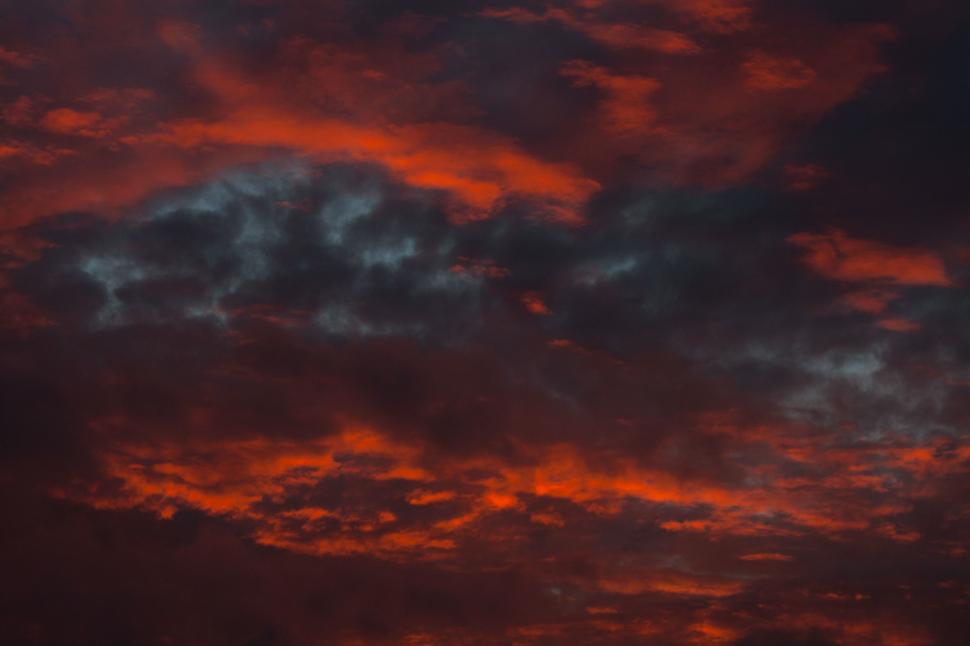 Free Image of Red Sky With Clouds and Plane in Distance 
