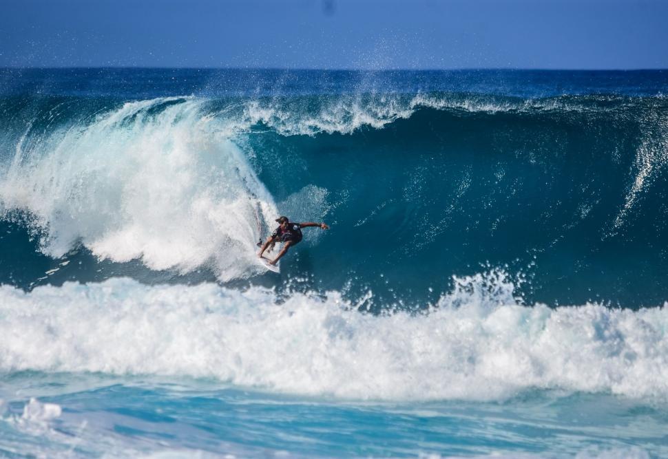 Free Image of Man Riding a Wave on Top of a Surfboard 