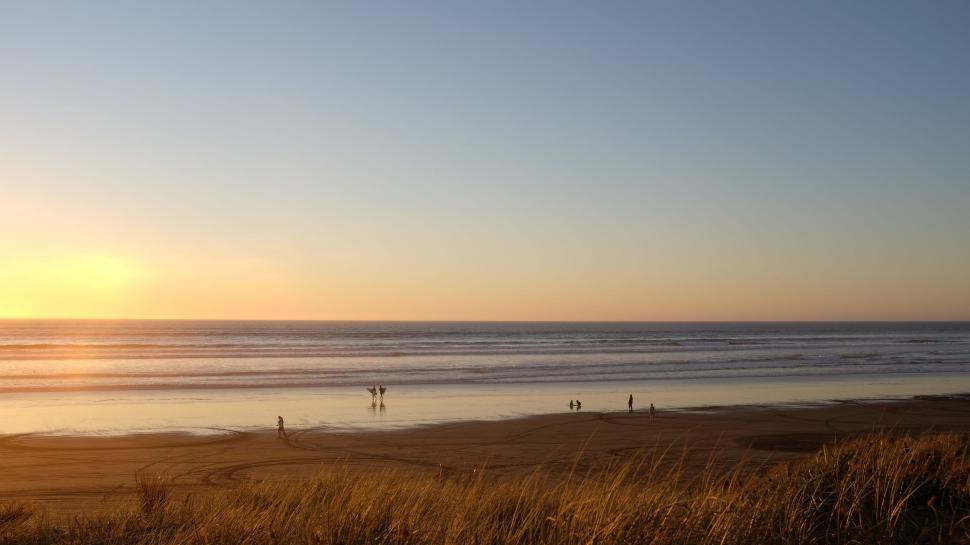 Free Image of Group of People Standing on Top of Sandy Beach 