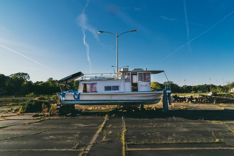 Free Image of White Boat Parked on Top of Parking Lot 