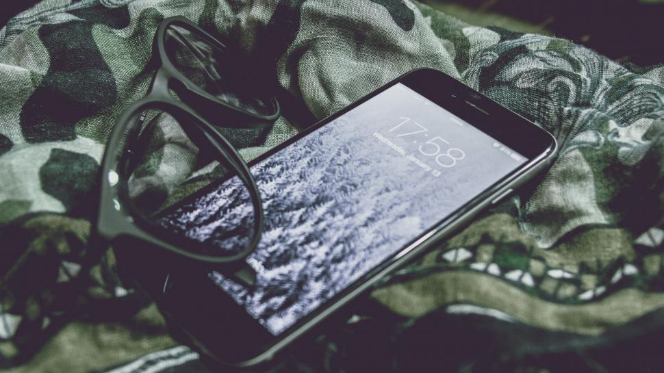 Free Image of Cell Phone and Glasses on Bed 