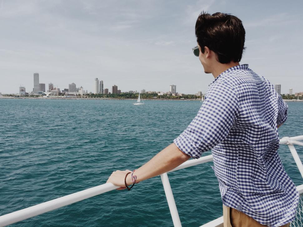 Free Image of Man Standing on Boat Looking Out at Water 